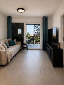 a living room with a couch and a flat screen tv at Sunset Aura in Sukošan