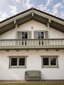 a white house with a balcony and a bench at Casa di Rosi in Schechen