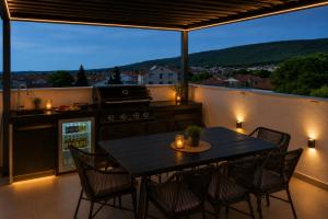 a kitchen with a table and chairs on a balcony at Sunset Aura in Sukošan
