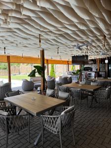 ein Restaurant mit Holztischen und Stühlen und aiting in der Unterkunft Complex Praga in Gorno Lakočerej
