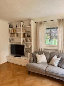 a living room with a couch and a flat screen tv at Casa di Rosi in Schechen