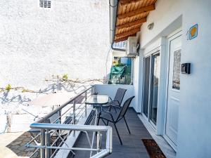 a balcony with chairs and a table on a building at Doukas Apartments & Studios in Skala Marion