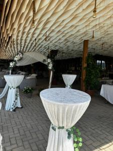Ein Tisch in einem Pavillon mit weißen Tischen und einem Sonnenschirm in der Unterkunft Complex Praga in Gorno Lakočerej + 67 Fotos