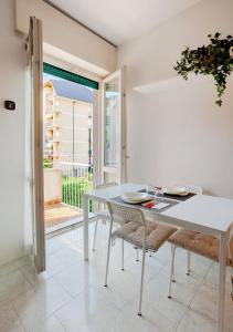 a white dining room with a white table and chairs at Nadilla House Castellanza Humanitas Liuc in Castellanza