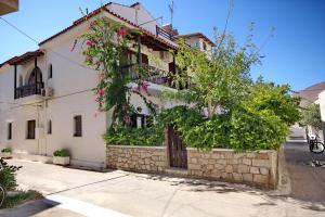 a house with flowers on the side of it at Pallas Pension in Elafonisos