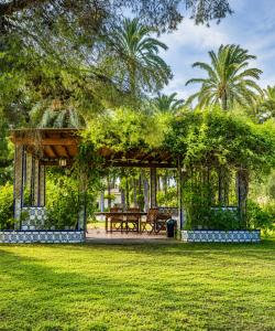 a gazebo with a picnic table in a park at Pink Lemon House in Elche