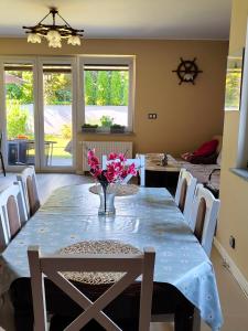 a dining room table with a vase of flowers on it at Brzask in Mosty