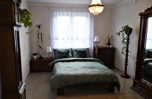 a bedroom with a bed with a window and a chandelier at U Edzia in Kochoń