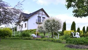 a white house with white swans in a garden at U Edzia in Kochoń