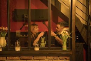 a man and a woman taking a picture in a window at La Maison Coquine Love Room Balnéo in Béthune +5 photos