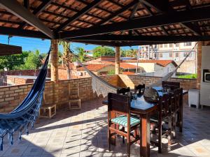 a patio with a table and chairs and a hammock at Loft NOA'House in Canoa Quebrada