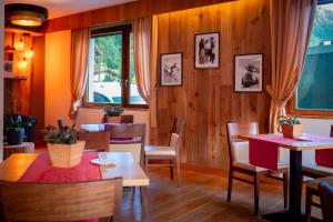 ein Restaurant mit Holzwänden, Tischen und Stühlen in der Unterkunft Olympic regina hotel in Pinzolo