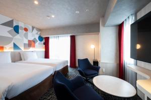 a hotel room with a bed and a tv at Richmond Hotel Namba Daikokucho in Osaka