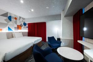 a hotel room with a bed and a table and chairs at Richmond Hotel Namba Daikokucho in Osaka