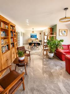 a living room with a red couch and tables at MARYPRATJOULOU Chambres d'hôtes- salle de bain privative- spacieux calme- GR34- bord de mer d'IROISE- Petit déjeuner compris PAIEMENT UNIQUEMENT SUR PLACE , ESPECES ,CB in Porspoder