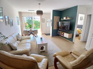 a living room with two couches and a tv at L'Escale Orléans Chambres d'hôtes in Orléans
