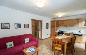 a living room with a red couch and a table at Casa Clelia in Pellizzano