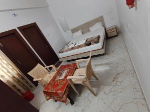 a bedroom with a bed and a table and chairs at Hotel Jaipur Royal in Patna