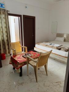 a room with a table and chairs and a bed at Hotel Jaipur Royal in Patna