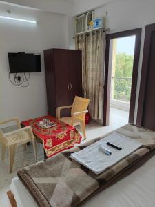 a bedroom with a bed and a chair and a tv at Hotel Jaipur Royal in Patna