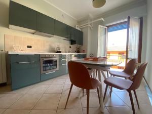 a kitchen with green cabinets and a table and chairs at L'ora del tè in Cremona