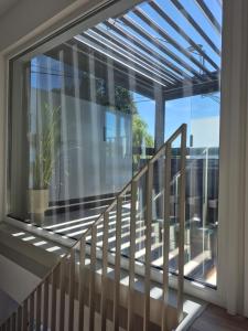 a balcony with a glass window and a staircase at Maison H - Logement de luxe avec jacuzzi privé et home cinéma immersif in Herstal