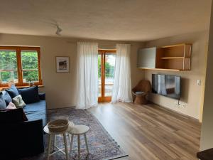 a living room with a blue couch and a tv at Modernes Apartment zum wohlfühlen und entspannen, max 4 Personen, Top Ausstattung in Trunkelsberg