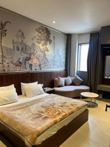 a bedroom with a large bed and a couch at Hotel Cassa Inn in Bathinda