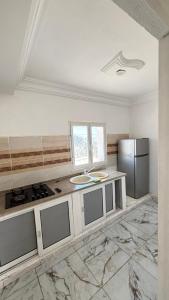 a kitchen with a stove and a refrigerator at hôtel Kridane in Houmt Souk