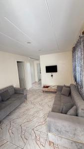 a living room with a couch and a flat screen tv at hôtel Kridane in Houmt Souk