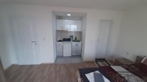an empty room with a kitchen with white cabinets at Apartments Viktor in Trpejca