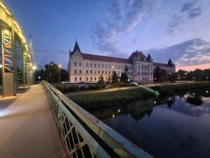 a large building sitting next to a body of water at Apartman Lola Ruža in Zrenjanin