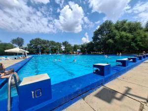a large swimming pool with people in the water at Apartman Lola Ruža in Zrenjanin