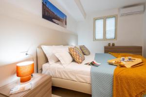 a bedroom with a bed and a table with a lamp at LOGGIATO HOUSE-Ispica in Ispica