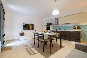 a kitchen and dining room with a table and chairs at LOGGIATO HOUSE-Ispica in Ispica