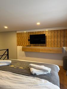 a bedroom with a bed with a flat screen tv on the wall at Çakıroğlu Villa Kent Pansiyon in Uzungöl