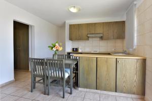 a kitchen with a table and chairs and a sink at Makronisos Village in Ayia Napa