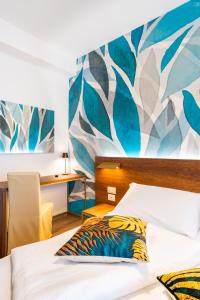 ein Schlafzimmer mit einem Bett und einem Wandgemälde an der Wand in der Unterkunft Hotel Antoniana in Caorle + 106 Fotos