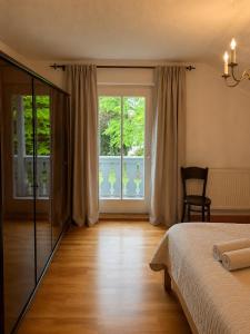 a bedroom with a bed and a window and a chair at Casa di Rosi in Schechen