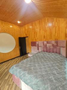 a bedroom with a large bed in a room with wooden walls at Family Villa with Pool in Əski İqrığ +33 photos