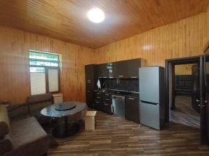 a kitchen with a couch and a table and a refrigerator at Family Villa with Pool in Əski İqrığ