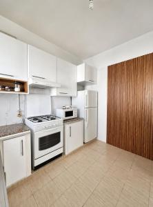 a kitchen with white cabinets and a stove and refrigerator at Superb apartment Monastir in Monastir +2 photos