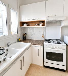 a white kitchen with a stove and a sink at Superb apartment Monastir in Monastir