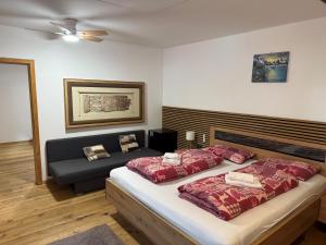 a bedroom with a bed and a couch at Gasthof Rafting Alm in Haiming