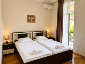 a bedroom with two beds and a window at Guest House Gardenia & Wine Cellar in Lagodekhi