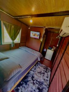 a small bedroom with a bed and a tv at Lamai Home 2 in Ko Yao Noi +8 photos