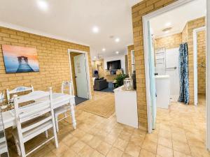a kitchen and dining room with a white table and a kitchen and a room at Champion Bay Coastal Stay in Geraldton +5 photos