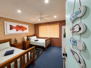 a bedroom with two beds and a bedroom with a fish picture at Champion Bay Coastal Stay in Geraldton