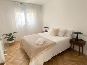a white bedroom with a bed with a tray on it at Praia - Boa Onda in Cee