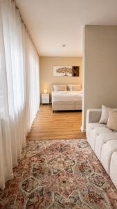 ein Wohnzimmer mit einem Bett und einer Couch in der Unterkunft NOVA Living, Balkon, Nähe Altstadt & kostenlose Tiefgarage in Würzburg